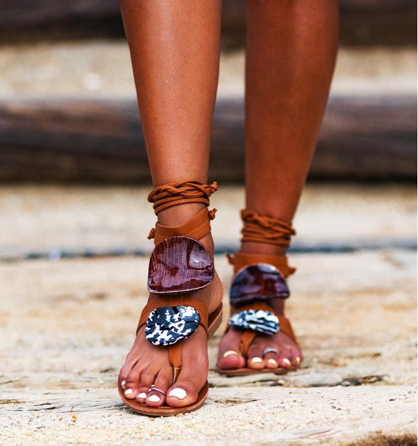 Camel flat sandals tied to the leg close-up Camel flat sandals tied to the leg close-up