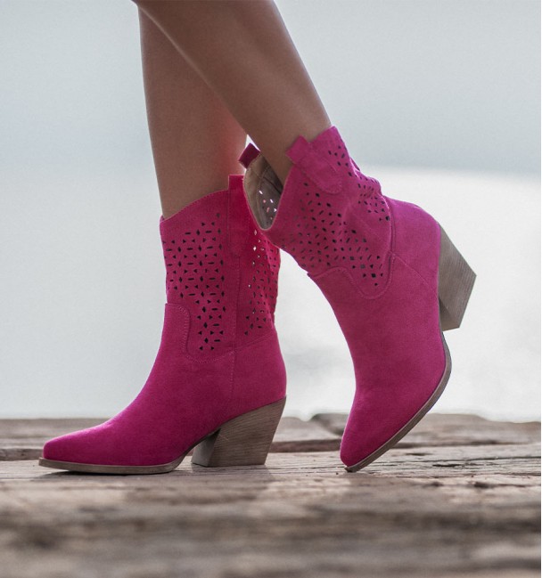 Botas cowboy fucsia con caña troquelada y tacón cubano, media caña y tiradores. Textil simil ante, suela y tacón de goma.