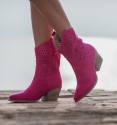 Botas cowboy fucsia con caña troquelada y tacón cubano, media caña y tiradores. Textil simil ante, suela y tacón de goma.