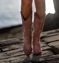 Foto frontal de botas cowboy rosas de material textil con bordados y tacón cubano