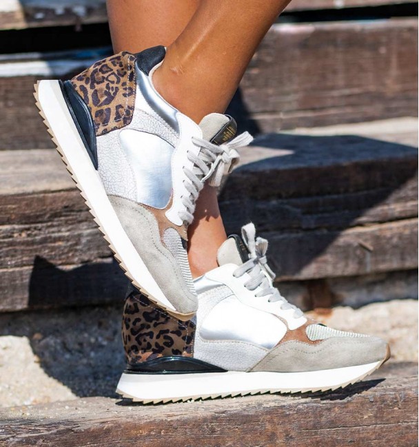 Tenís com uma sola de cunha leve. Materiais combinados com impressão leopardo, prata e têxtil.