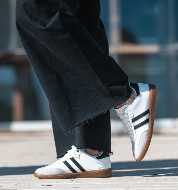 zapatillas deportivas combinadas en serraje gris, cuerina blanca y lineas negras. Suela goma marrón