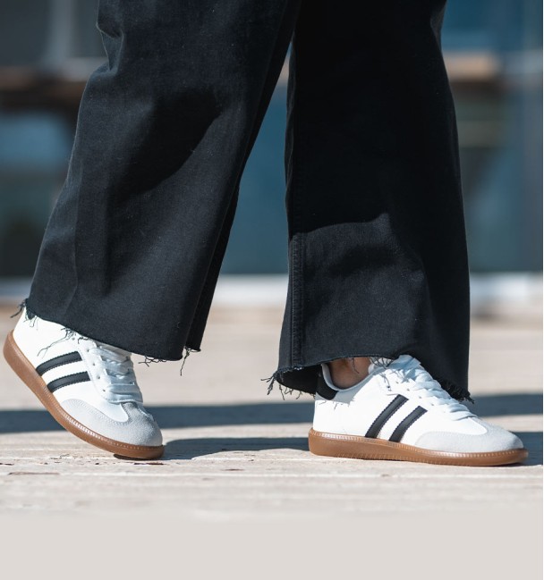 zapatillas deportivas combinadas en serraje gris, cuerina blanca y lineas negras. Suela goma marrón. Animal free