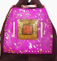 Bolso tipo saco en cuero y bolsillo delantero piel de potro lila con pintas doradas. Pieza de bronce y piedra en el centro
