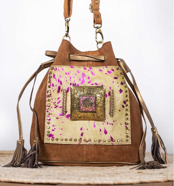 Bolso tipo saco en cuero y bolsillo delantero piel de potro pistacho con pintas lila. Pieza de bronce y piedra en el centro