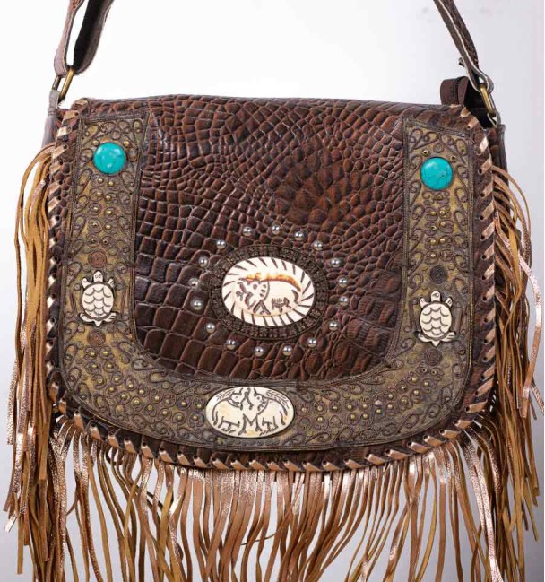 bolso boho de cuero con adornos de latón y hueso tallado, primer plano