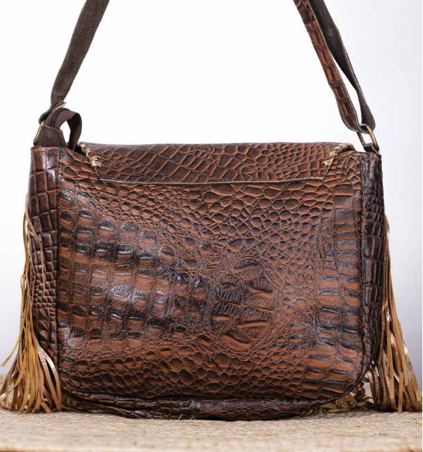 bolso boho cuero con adornos de latón y hueso tallado, primer plano