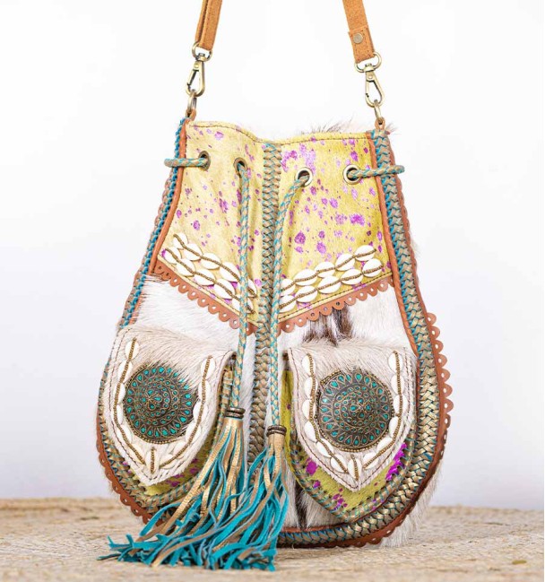 bolso bandolera de pelo de porto verde con manchas lila y adornos étnicos.