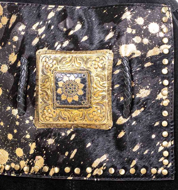Bolso tipo saco en cuero y bolsillo delantero piel de potro negro con pintas doradas. Pieza de bronce y piedra en el centro 2