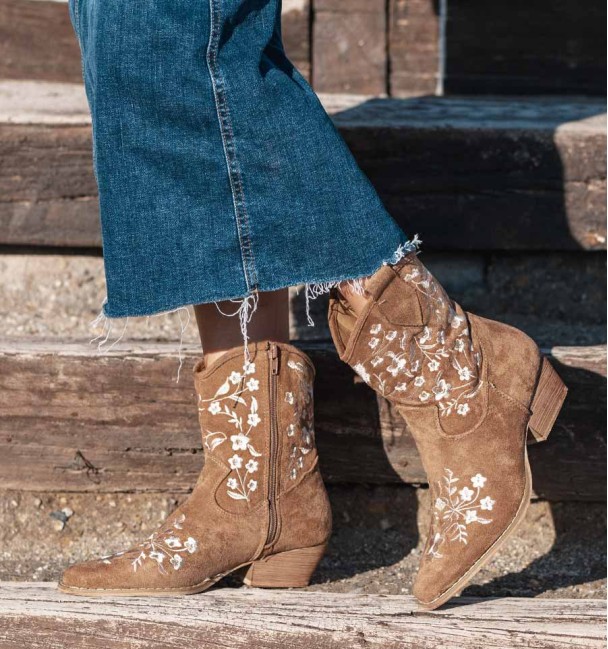 Botas cowboy castanhas com flores bordadas. De material têxtil e salto médio.