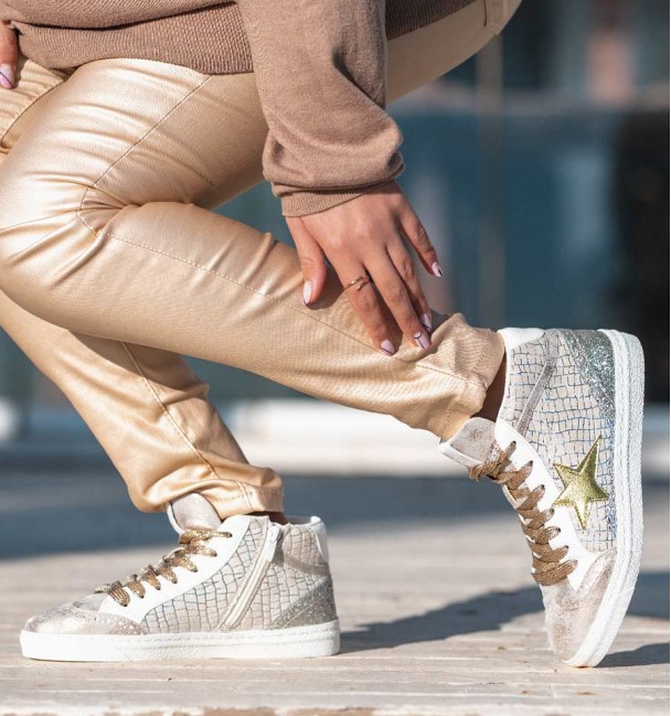 Tenis em branco e dourado com estrela dourada. Atacadores dourados.