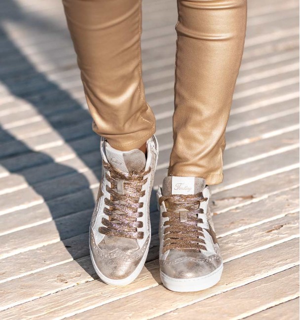 Zapatillas en blanco y dorado en botin con cremallera interior. Cordones dorados.