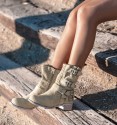 beige coloured cowboy boots with buckles and die-cut mid-calf. Animal free