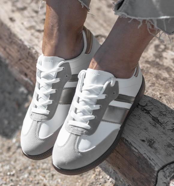 women's leather sneakers with two silver stripes and brown rubber sole.