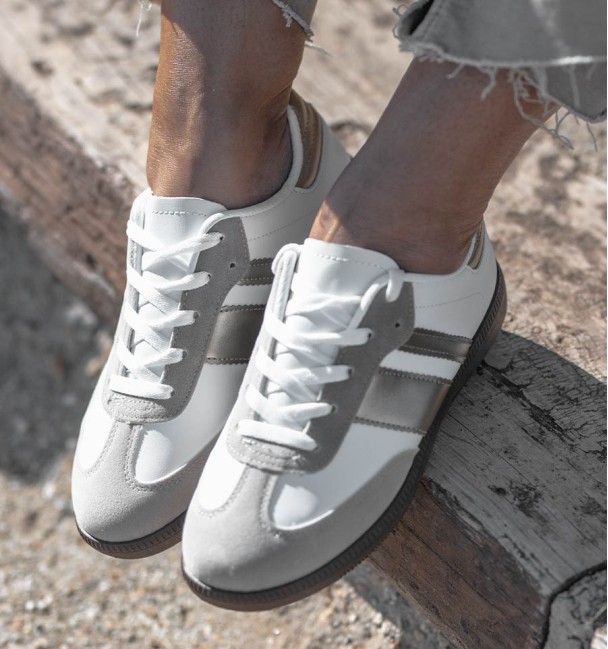 women's leather sneakers with two silver stripes and brown rubber sole.