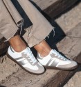 women's leather sneakers with two silver stripes and brown rubber sole.