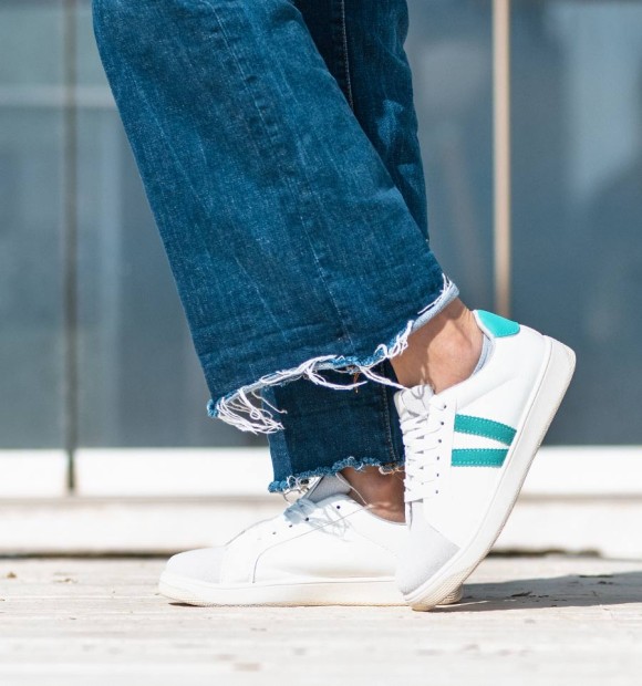 White vegan leather sneakers with two green lines and laces. 2
