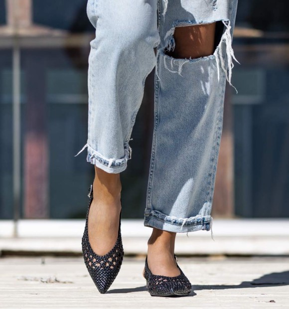 Black ankle boot with wide heel and buckle at the ankle. Braided instep