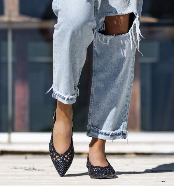 Black ankle boot with wide heel and buckle at the ankle. Braided instep