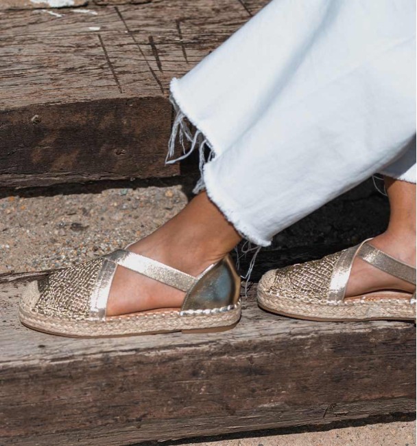 golden espadrilles with crossed elastic straps on the instep and original woven toe cap. Animal free
