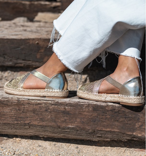 golden espadrilles with crossed elastic straps on the instep and original woven toe cap. Animal free