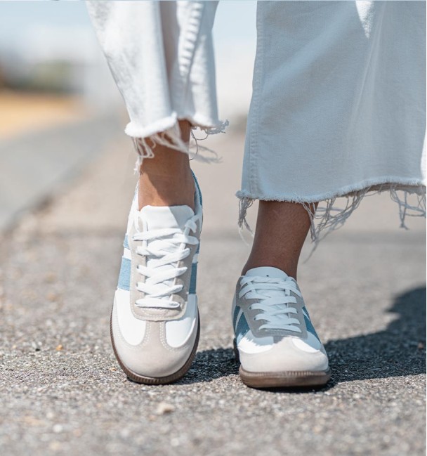 zapatillas deportivas combinadas en serraje gris, cuerina blanca y lineas vaqueras. Suela goma marrón