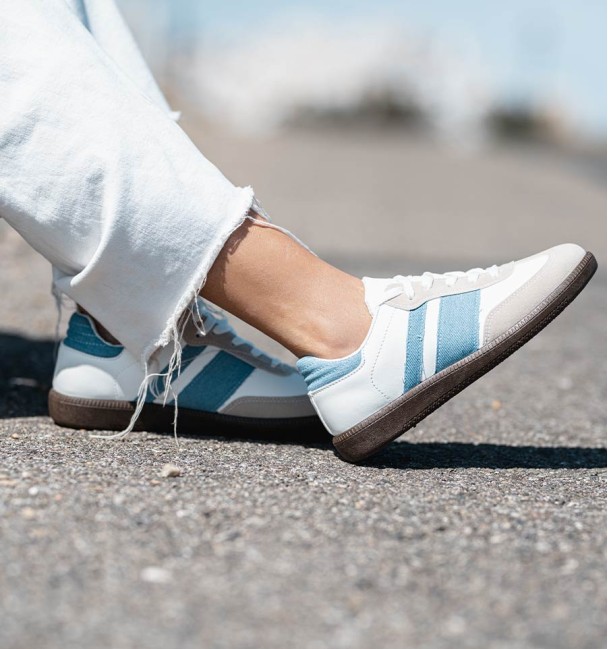 zapatillas deportivas combinadas en serraje gris, cuerina blanca y lineas vaqueras. Suela goma marrón