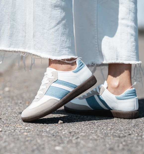 zapatillas deportivas combinadas en serraje gris, cuerina blanca y lineas vaqueras. Suela goma marrón