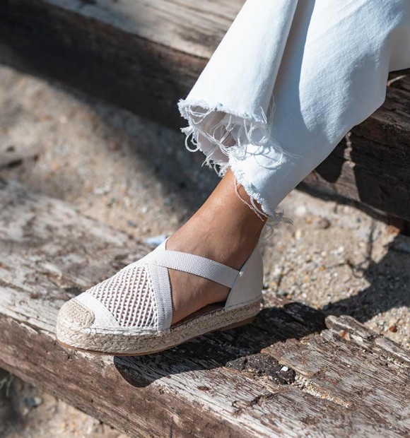beige espadrilles with crossed elastic straps on the instep and original woven toe cap. 2