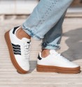 white trainers with double brown rubber sole and 4 black stripes. Animal free.