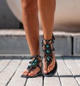 sandalias romanas negras con hoja en el empeine y piedras turquesas, tachuelas en las tiras