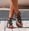 sandalias romanas negras con hoja en el empeine y piedras turquesas, tachuelas en las tiras