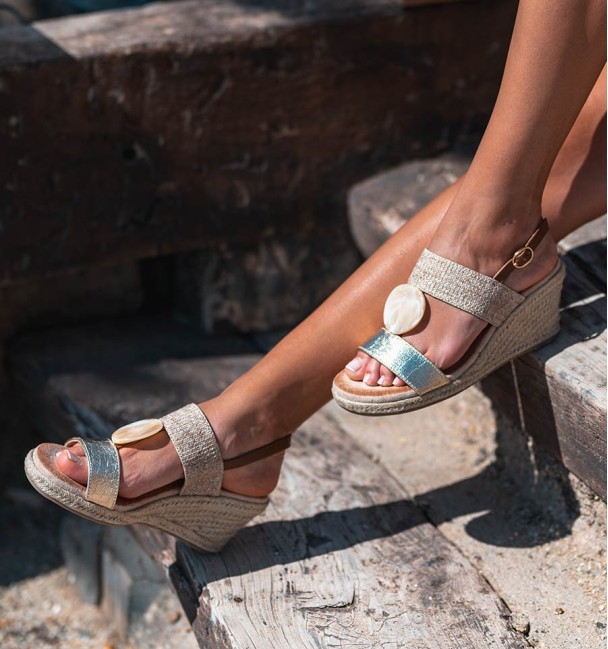 Sandálias bege e douradas com cunha de esparto e decoração bege no peito do pé. Sandálias bege e douradas com cunha de esparto e decoração bege no peito do pé.