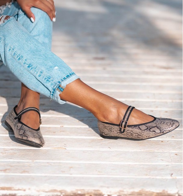 Sapatos de bailarina com estampado animal com efeito cobra, com tira no peito do pé e fivela. Rebordo em preto.
