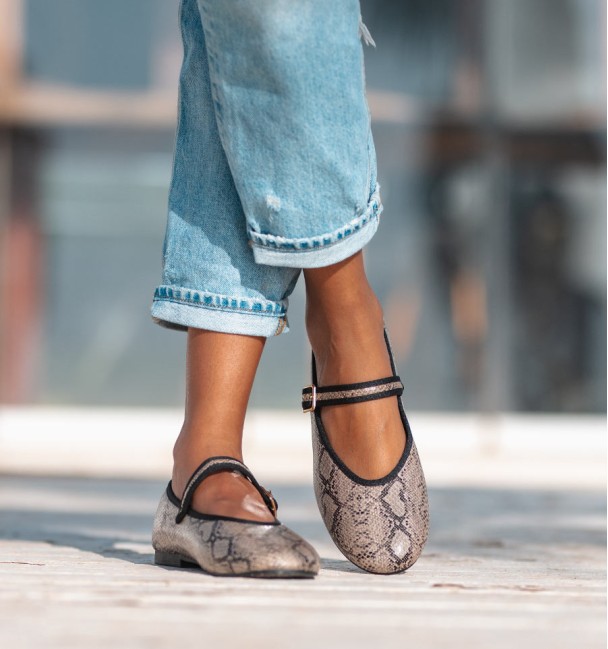 Sapatos de bailarina com estampado animal com efeito cobra, com tira no peito do pé e fivela. Rebordo em preto.