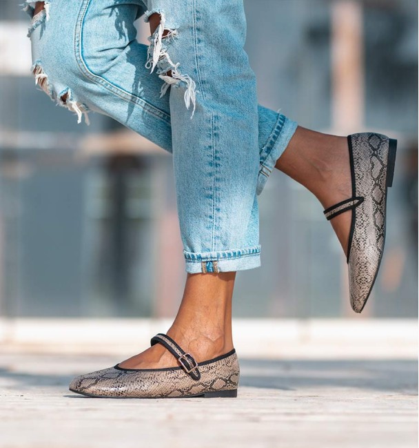 Sapatos de bailarina com estampado animal com efeito cobra, com tira no peito do pé e fivela. Rebordo em preto.