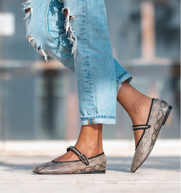 Sapatos de bailarina com estampado animal com efeito cobra, com tira no peito do pé e fivela. Rebordo em preto.