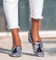 White and black wide low heel shoes, zebra print, trim and tassels in black. Textile material imitation natural hair.