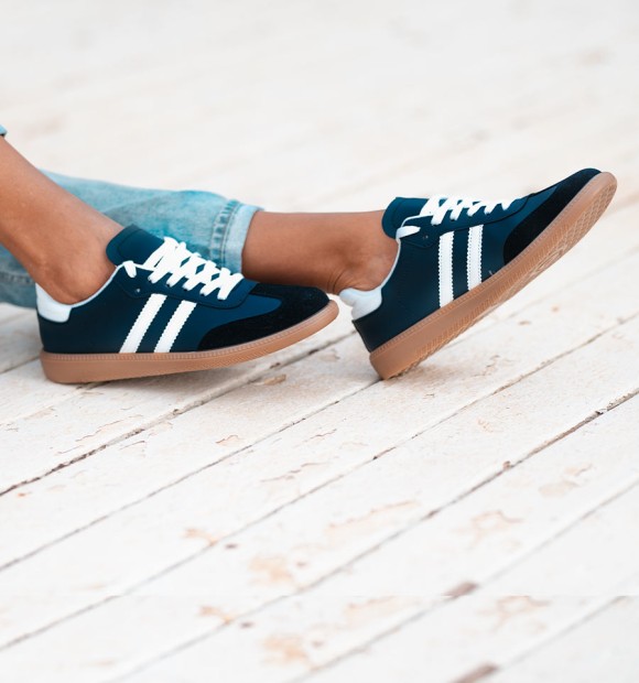 Sapatilhas azul-marinho com riscas e atacadores brancos, sola de borracha. Ténis na moda 2