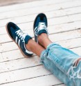 navy blue trainers with white stripes and laces, rubber sole. Trendy sneakers
