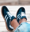 navy blue trainers with white stripes and laces, rubber sole. Trendy sneakers