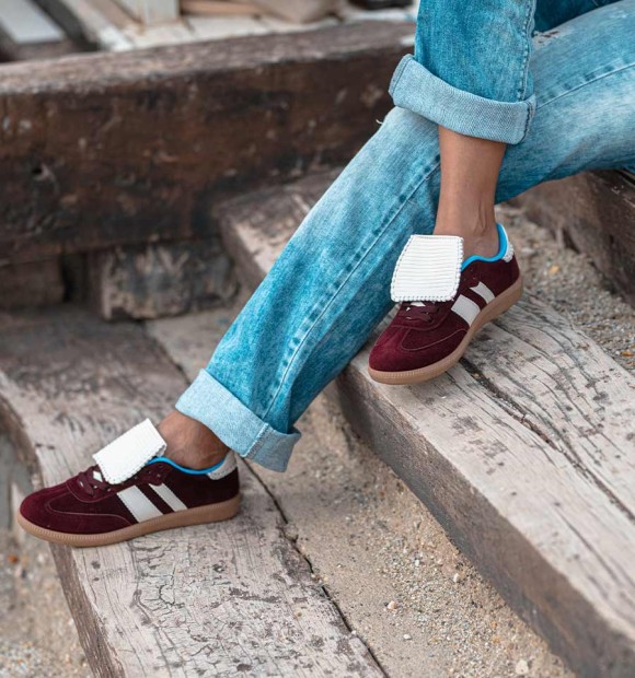 Wine color trainers with white tongue and two lateral white stripes. Trendy women's trainers. Animal free 2
