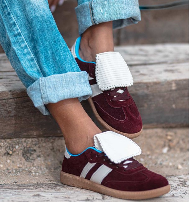 Sapatilhas cor de vinho com língua branca e duas riscas laterais brancas. Sapatilhas de senhora na moda. Sem animais