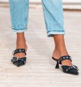 zapato destalonado en color negro con tacón bajo, tira con tachuelas y hebillas en empeine. Cuerina, animal free.