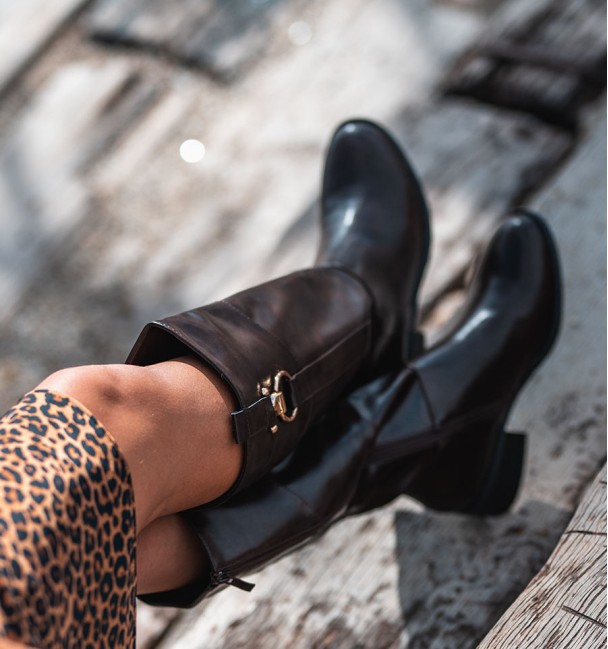 Botas de cano alto estilo equestre em pele castanha com estribo dourado no topo