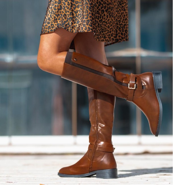 Botas de cano alto castanhas com fecho interior e elástico no lado exterior, pormenor de fivela no tornozelo. Vegan