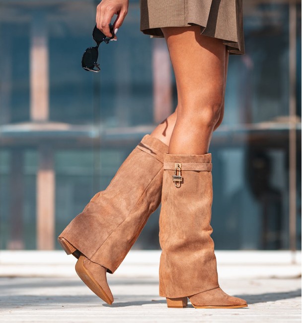 Women's brown high boots with flap and heel. Strap and padlock on the top