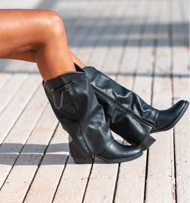 botas negras de mujer, con solapa y tacón . Hebilla y  tachuelas cadena