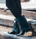 black low boots in gaiter with studs on the toe bordering the bottom and back, wide heel and pointed toe finish.