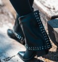 black low boots in gaiter with studs on the toe bordering the bottom and back, wide heel and pointed toe finish.